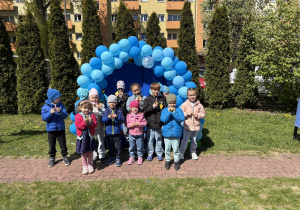 zdjęcie grupy dzieci na tle girlandy zrobionej z niebieskich balonów, na tablicy napis Niebieskie Igrzyska