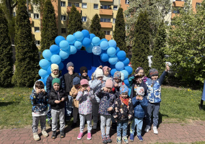 zdjęcie grupy dzieci na tle girlandy zrobionej z niebieskich balonów, na tablicy napis Niebieskie Igrzyska
