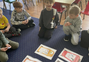 Dzieci w kole segregują odpady.