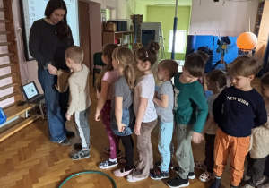 Dzieci ustawione w szeregu podchodzą do pani.