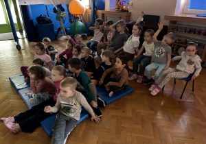 Dzieci siedzą i oglądają prezentację.