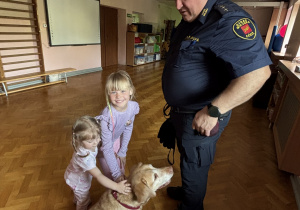 Dziecko głaszcze psa policyjnego.