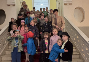 Dzieci pozują do zdjęcia na schodach teatru.