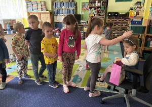 Dzieci podchodzą do dziewczynki i składają jej życzenia.