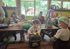 dzieci podczas wycieczki do pasieki w Lipce siedzą przy stołach
