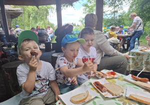 dzieci podczas wycieczki do pasieki w Lipce jedzą kiełbaski