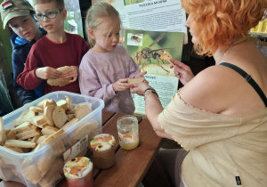 dzieci podczas wycieczki do pasieki w Lipce jedzą chleb z miodem
