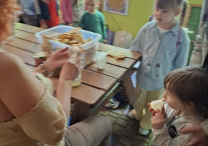 dzieci podczas wycieczki do pasieki w Lipce jedzą chleb z miodem