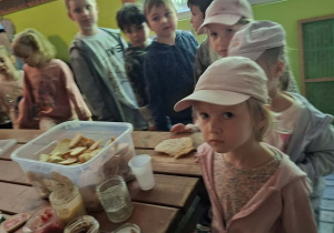 dzieci podczas wycieczki do pasieki w Lipce jedzą chleb z miodem
