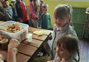 dzieci podczas wycieczki do pasieki w Lipce jedzą chleb z miodem