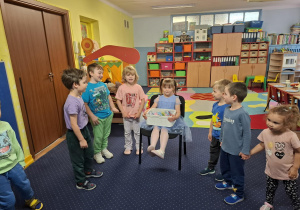 dziewczynka świętuje urodziny, dzieci składają jej życzenia