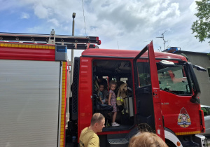 dzieci zwiedzają wnętrze wozu strażackiego