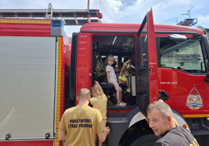 dzieci odwiedzają wnętrze wozu strażackiego