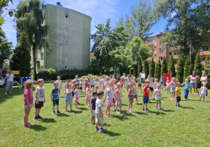 dzieci w ogródku przedszkolnym ćwiczą do muzyki