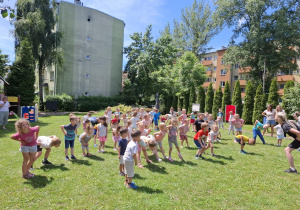 dzieci w ogródku przedszkolnym ćwiczą do muzyki