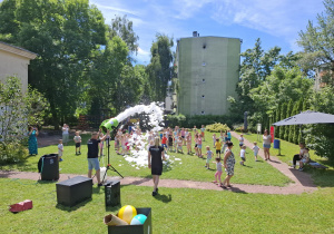 piana party w ogrodzie przedszkolnym, dzieci biegają po trawie, piana unosi się do góry