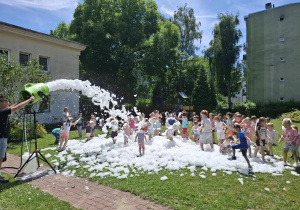 piana party w ogrodzie przedszkolnym, dzieci biegają po trawie, piana unosi się do góry