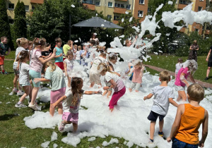 piana party w ogrodzie przedszkolnym, dzieci biegają po trawie, piana unosi się do góry