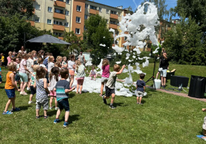 piana party w ogrodzie przedszkolnym, dzieci biegają po trawie, piana unosi się do góry