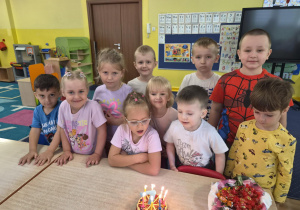 dziewczynka obchodzi urodziny, na stoliku widać tort z cyferką 7
