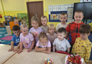 dziewczynka obchodzi urodziny, na stoliku widać tort z cyferką 7