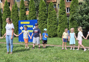 dzieci w ogródku przedszkolnym wspólnie bawią się przy muzyce