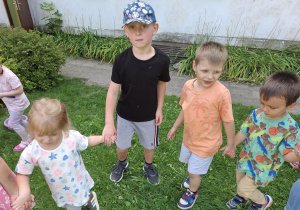dzieci w ogródku przedszkolnym wspólnie bawią się przy muzyce