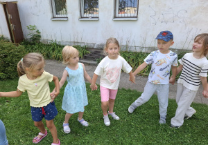 dzieci w ogródku przedszkolnym wspólnie bawią się przy muzyce