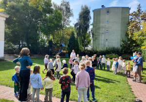 Dzieci bawią się w ogrodzie przy muzyce.