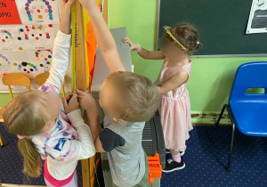 Dzieci mierzą przedmioty w klasie.
