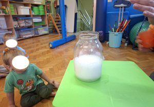 dzieci biorą udział w zajęciach sensorycznych, dotykają, chodzą, obserwują materiały przyrodnicze