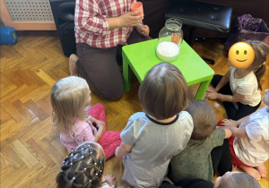 Dzieci oglądają eksperyment z kukurydzą.