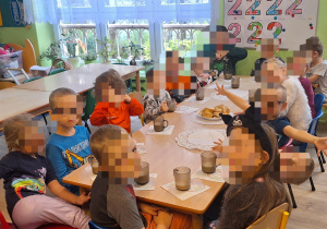 Dzieci siedzą przy stole.