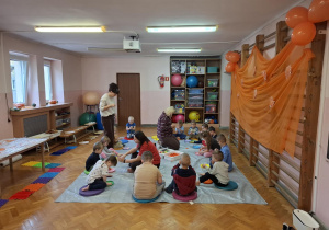 zajęcia sensoryczne na sali gimnastycznej, dzieci malują, dotykają stopami i dłońmi różnych faktur