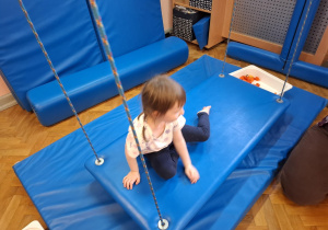 zajęcia sensoryczne na sali gimnastycznej, dzieci malują, dotykają stopami i dłońmi różnych faktur