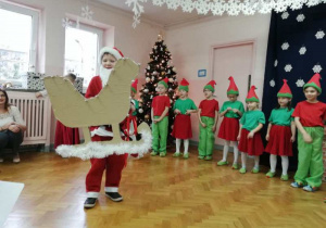 Święty Mikołaj z grupy w saniach 4 na scenie.