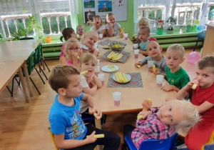 Dzieci siedzą przy stole podczas wspólnego posiłku z okazji "Dnia przedszkolaka".