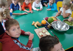 Dzieci degustują różne owoce.