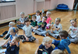 Dzieci bawią się liśćmi do muzyki.
