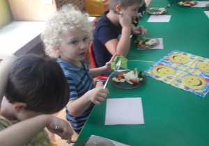 Dzieci wymieniają warzywa znajdujące się na ich talerzykach.
