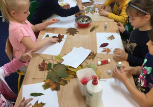 Dzieci tworzą prace plastyczne z darów jesieni.