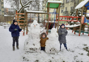 dzieci bawią się na śniegu w ogrodzie przedszkolnym