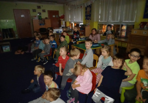 Duża grupa dzieci siedzi na krzesłach w klasie.