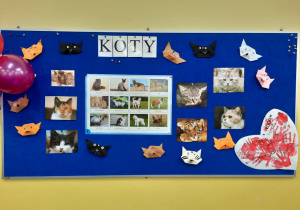 Tablica poświecona kotom. Na tablicy znajduje się napis, serce i koty wykonane przez dzieci techniką origami oraz zdjęcia kotów.