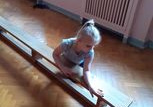 Dziewczynka mierzy ławkę łokciami.