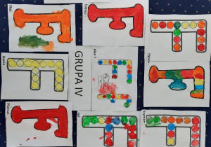 Na podłodze leżą pokolorowane farbami litery 'F,f" według pomysłu dzieci.