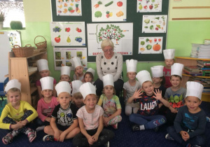 Wspólne zdjęcie dzieci w czapkach kucharskich wraz z babcią.