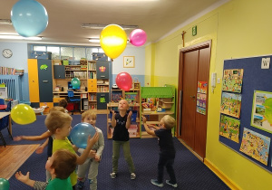 dzieci w klasie podrzucają balony