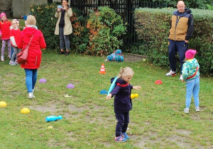 dzieci biorą udział w sportowej rywalizacji na podwórku przedszkolnym