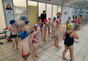grupa dzieci w kostiumach kąpielowych na basenie